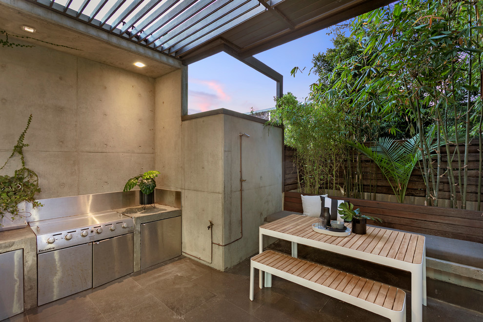 Immagine di un piccolo patio o portico industriale dietro casa con un giardino in vaso, pavimentazioni in pietra naturale e una pergola