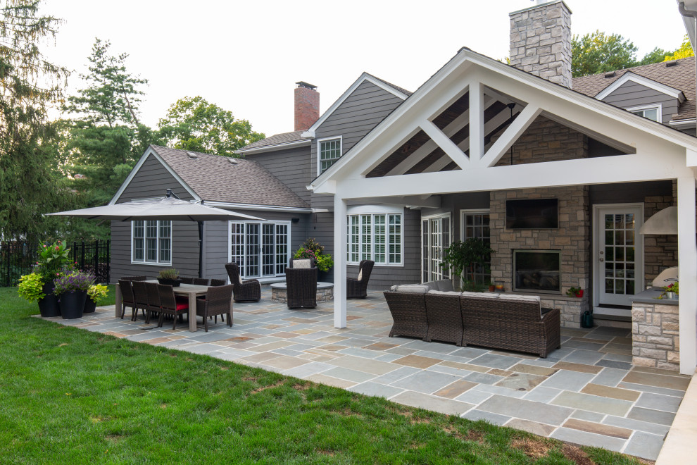 Modelo de patio tradicional renovado grande en patio trasero y anexo de casas con cocina exterior y adoquines de piedra natural