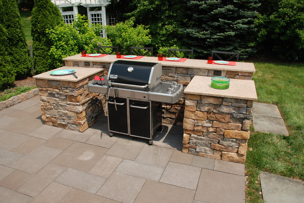 Aménagement d'une petite terrasse arrière classique avec des pavés en pierre naturelle et une cuisine d'été.
