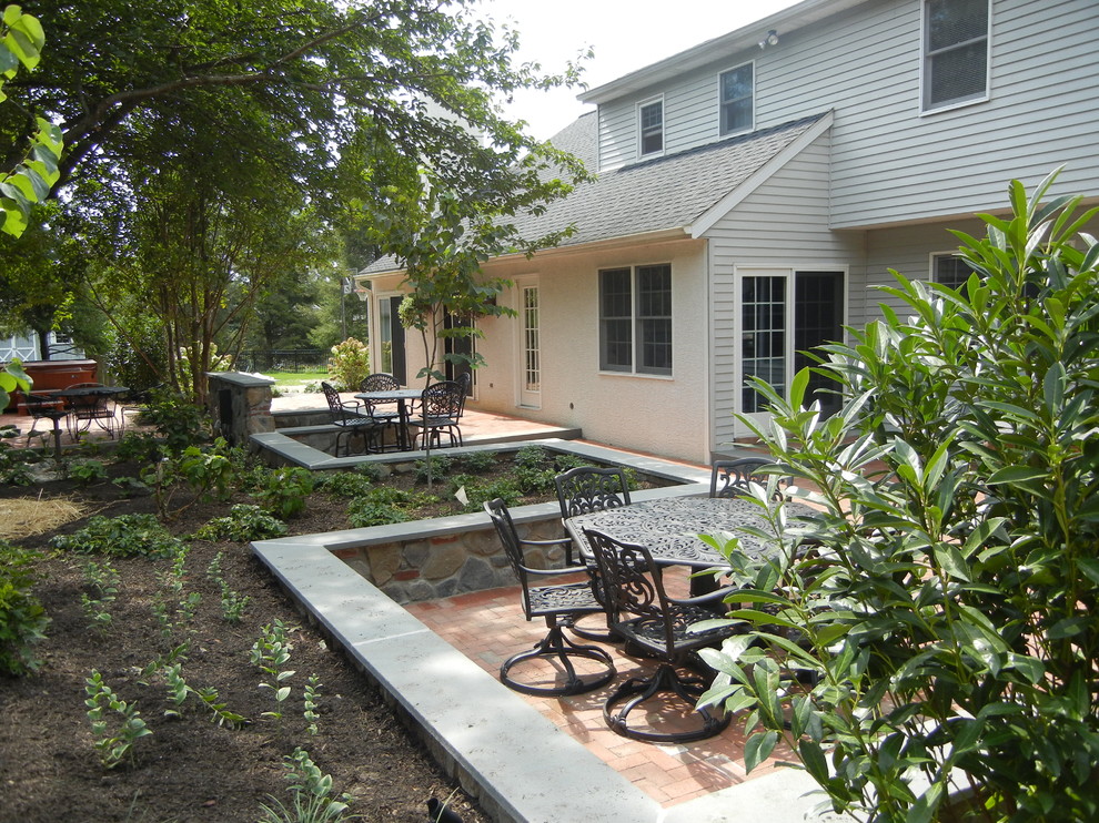 Diseño de patio bohemio de tamaño medio sin cubierta en patio trasero con chimenea y adoquines de ladrillo