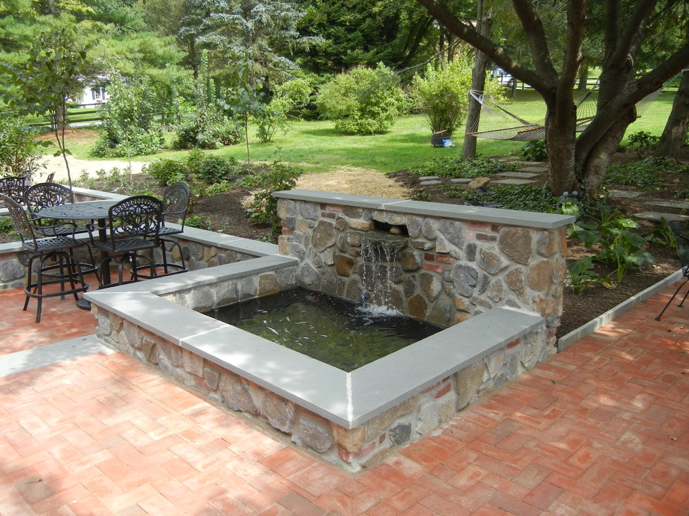 Foto di un piccolo patio o portico country dietro casa con fontane, pavimentazioni in mattoni e un gazebo o capanno