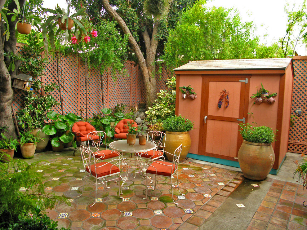 Cette image montre une terrasse avec des plantes en pots bohème de taille moyenne avec une cour, du carrelage et aucune couverture.