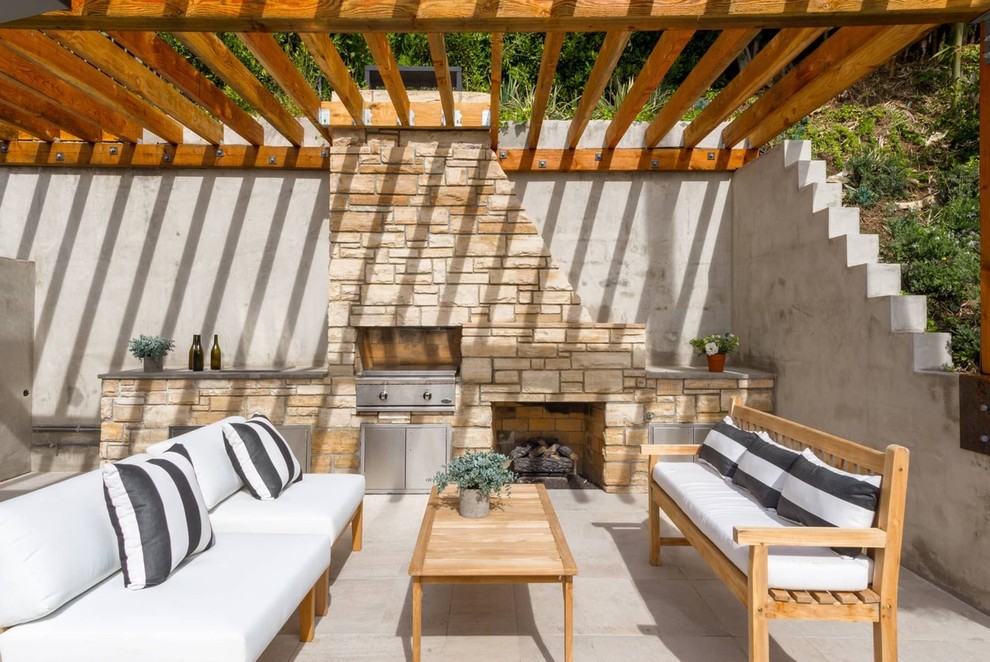 Aménagement d'une terrasse arrière contemporaine avec une cuisine d'été et une pergola.