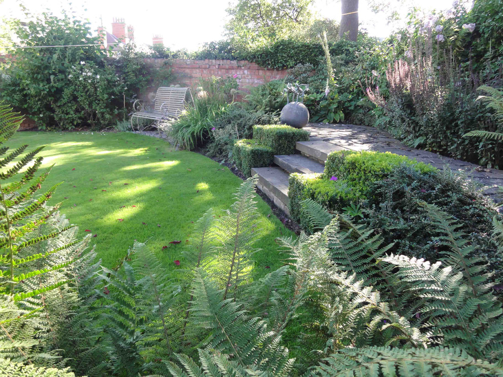 This is an example of a medium sized contemporary courtyard garden in Cheshire with natural stone paving.