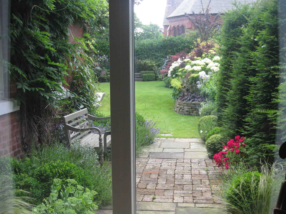 Imagen de jardín contemporáneo de tamaño medio en patio con adoquines de piedra natural