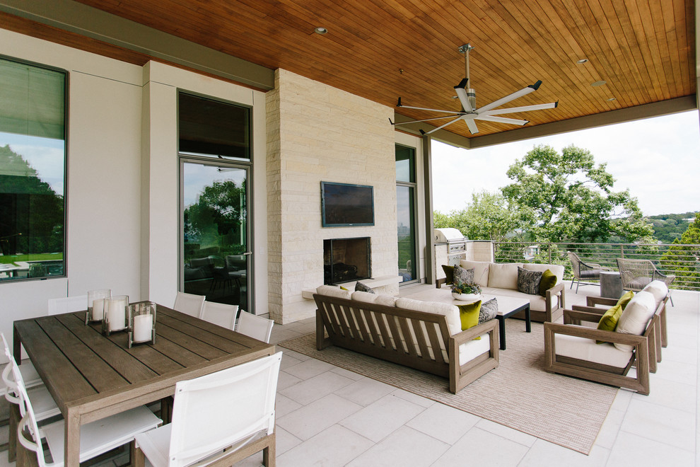Inspiration for a huge modern backyard stone patio kitchen remodel in Austin with a roof extension