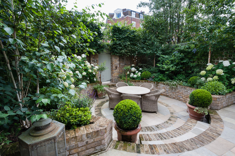 Example of a small classic brick patio design in London