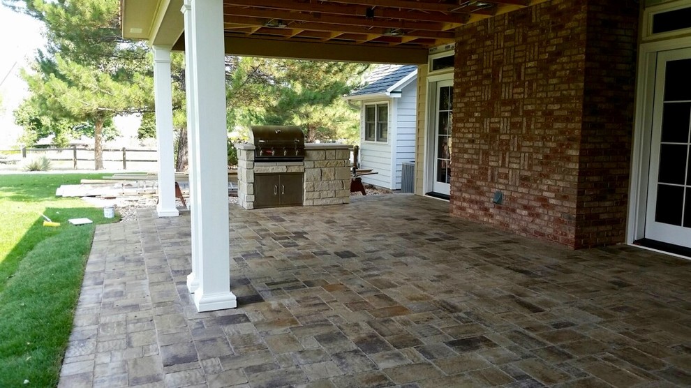 Esempio di un patio o portico classico dietro casa con pavimentazioni in cemento e un tetto a sbalzo