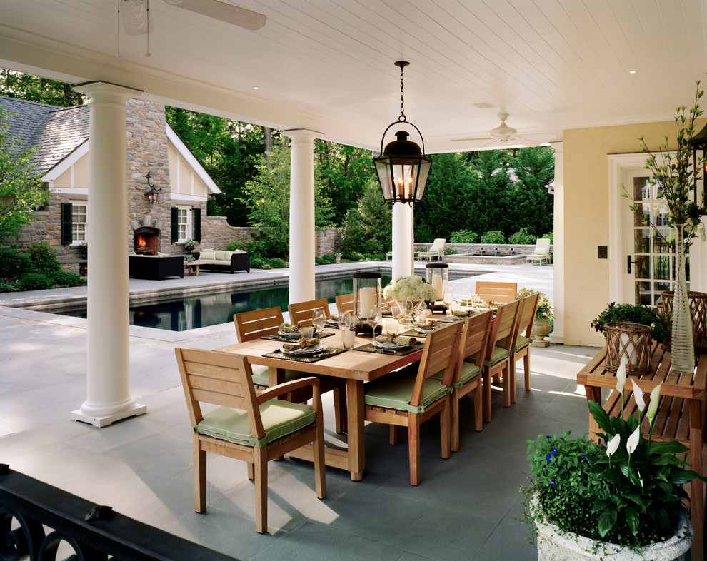 Immagine di un grande patio o portico classico dietro casa con pavimentazioni in cemento e un tetto a sbalzo
