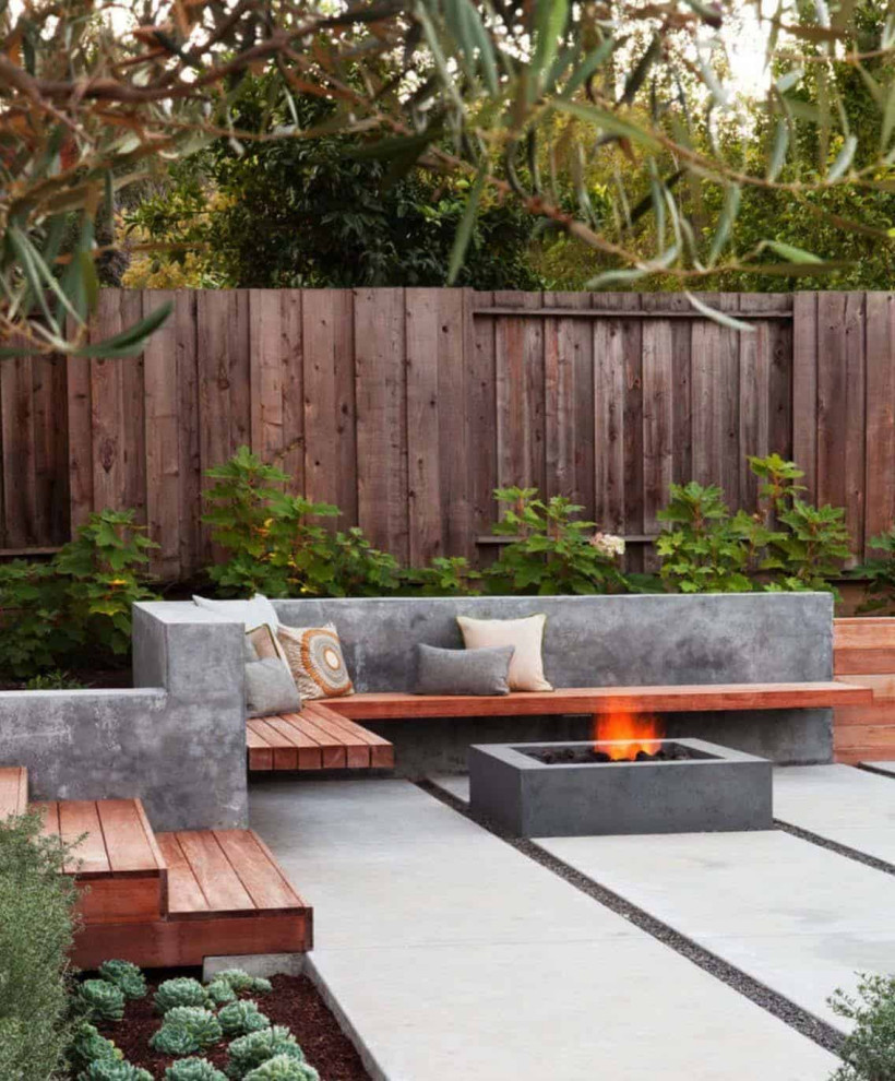 This is an example of a small modern back patio in Los Angeles with a fire feature, concrete paving and no cover.