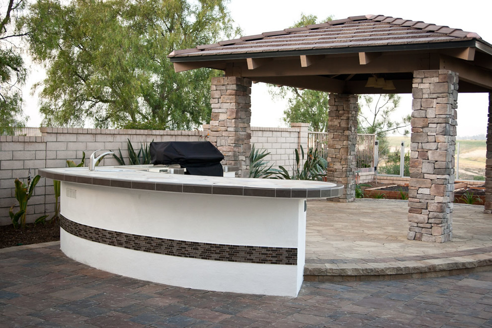 Large backyard concrete paver patio kitchen photo in San Diego