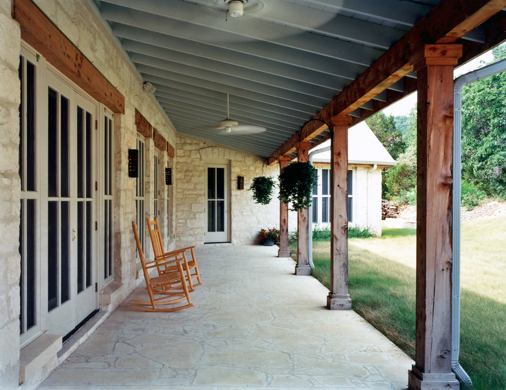Esempio di un patio o portico stile rurale di medie dimensioni e davanti casa con cemento stampato e un tetto a sbalzo