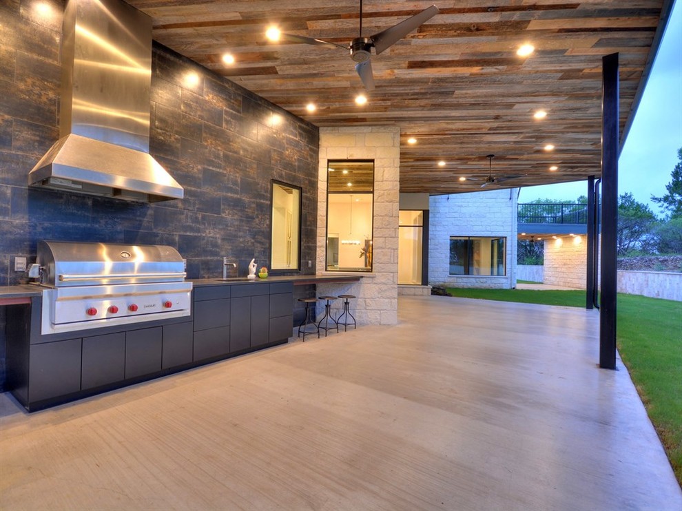 Patio kitchen - large contemporary backyard patio kitchen idea in Austin with a roof extension
