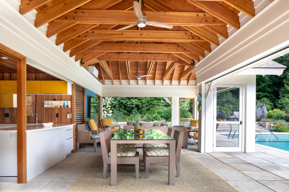 Idee per un grande patio o portico stile marino dietro casa con pavimentazioni in pietra naturale e un tetto a sbalzo