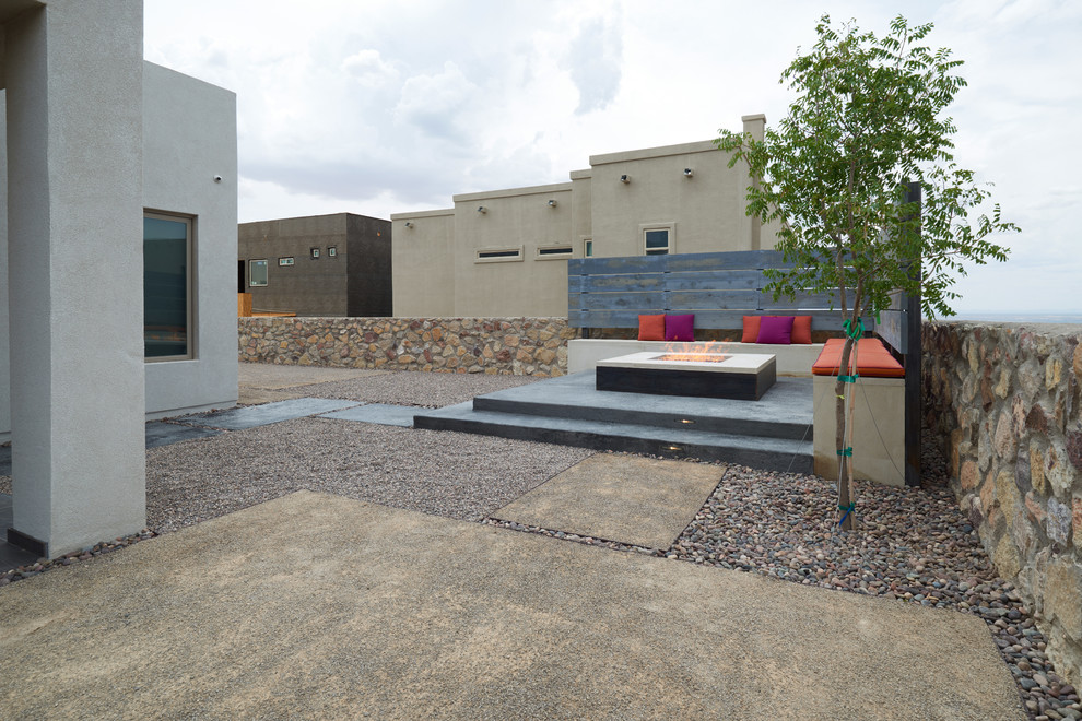 Cette image montre une petite terrasse arrière design avec un foyer extérieur, une dalle de béton et aucune couverture.