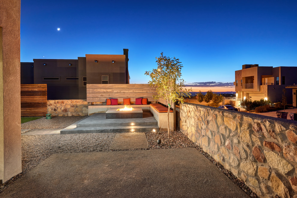 Ejemplo de patio contemporáneo pequeño sin cubierta en patio trasero con brasero y losas de hormigón