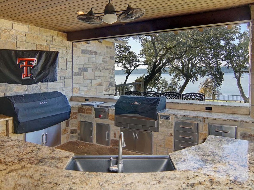 Cette image montre une très grande terrasse arrière chalet avec une cuisine d'été, une dalle de béton et une extension de toiture.