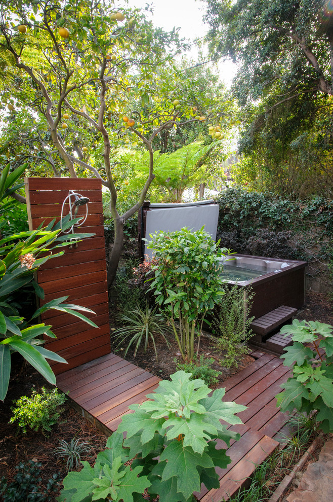 Modelo de patio contemporáneo de tamaño medio sin cubierta en patio trasero con ducha exterior y entablado