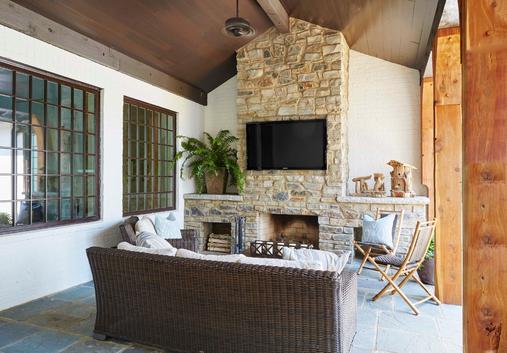 Idées déco pour une terrasse latérale classique de taille moyenne avec un foyer extérieur, des pavés en pierre naturelle et une extension de toiture.