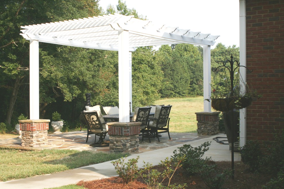 Medium sized eclectic side patio in Atlanta with a vegetable patch, natural stone paving and a pergola.