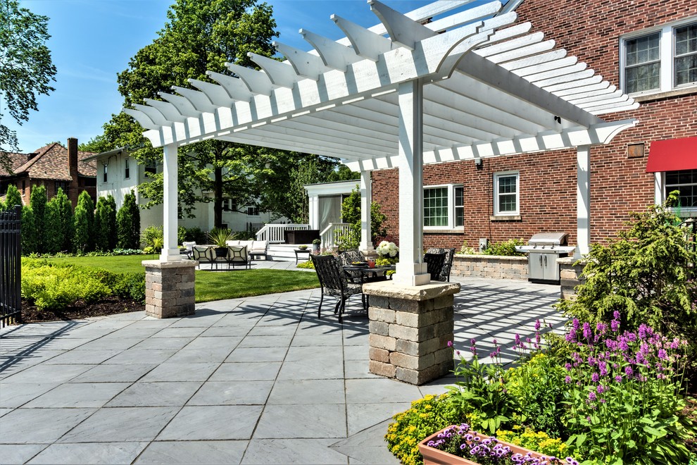 Foto de patio clásico renovado grande en patio trasero con brasero, adoquines de piedra natural y pérgola