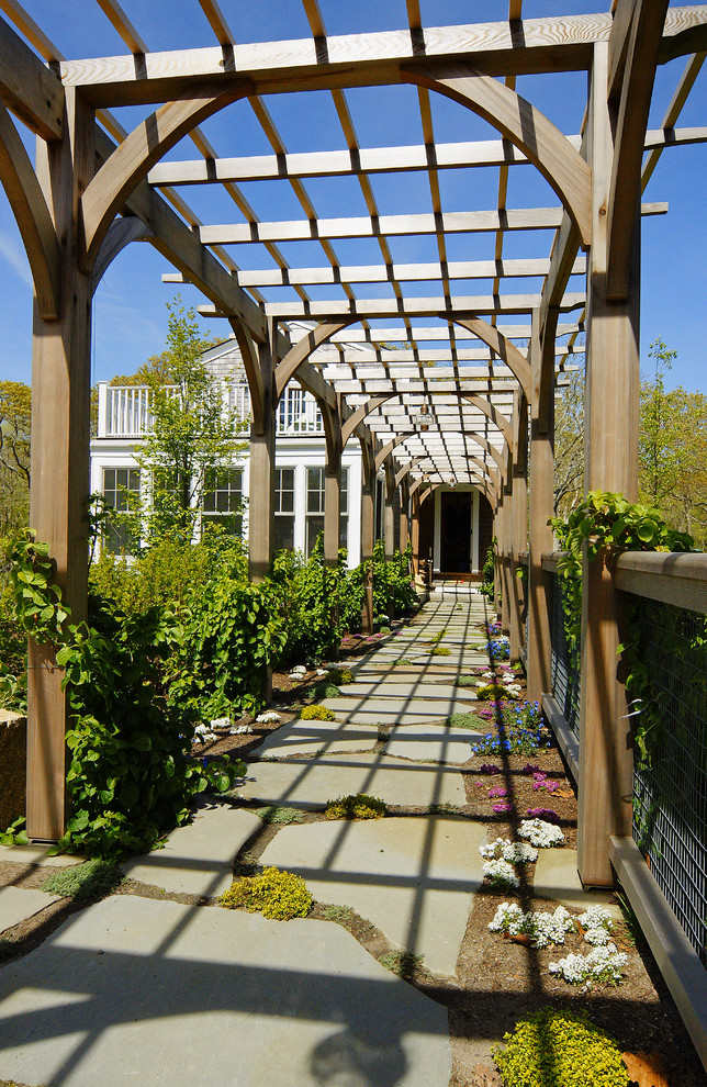 Immagine di un grande patio o portico tradizionale dietro casa con pavimentazioni in pietra naturale e una pergola