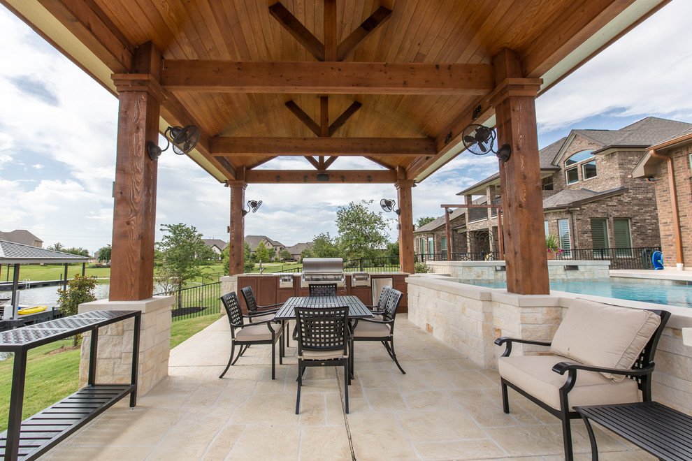 Foto de patio clásico de tamaño medio en patio trasero con cocina exterior, adoquines de piedra natural y cenador