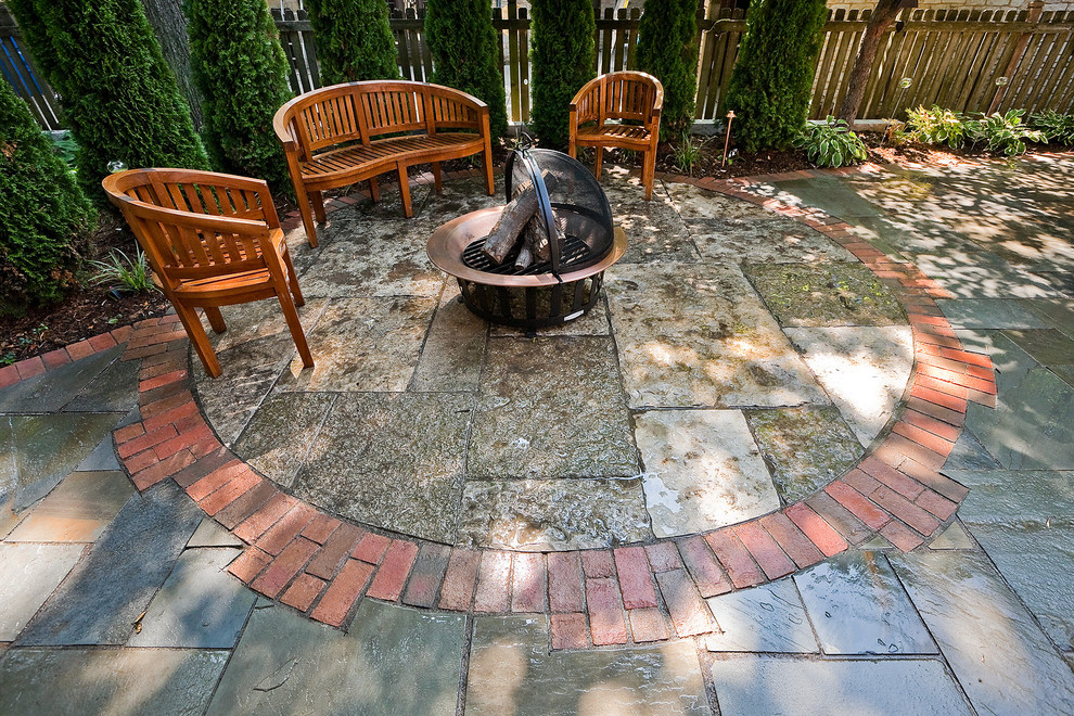 Design ideas for a medium sized traditional back patio in Milwaukee with a fire feature and natural stone paving.