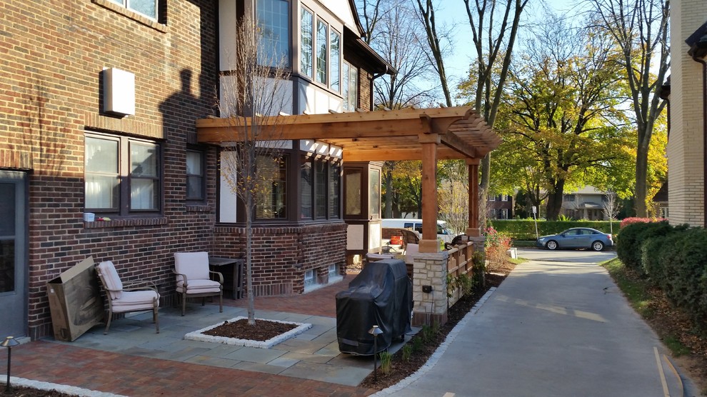 Foto de patio tradicional de tamaño medio en patio lateral con adoquines de piedra natural y pérgola