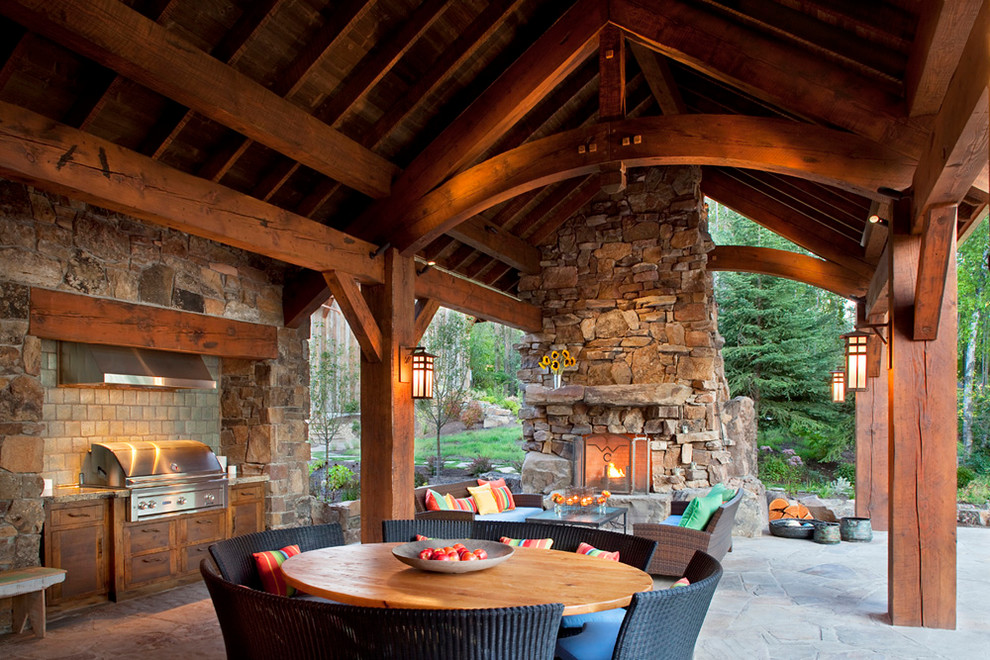 Inspiration for a rustic patio remodel in Other with a fire pit and a roof extension