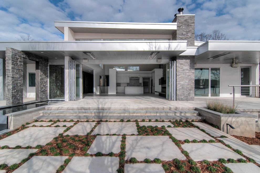 Пример оригинального дизайна: двор среднего размера на заднем дворе в стиле модернизм с мощением тротуарной плиткой и навесом