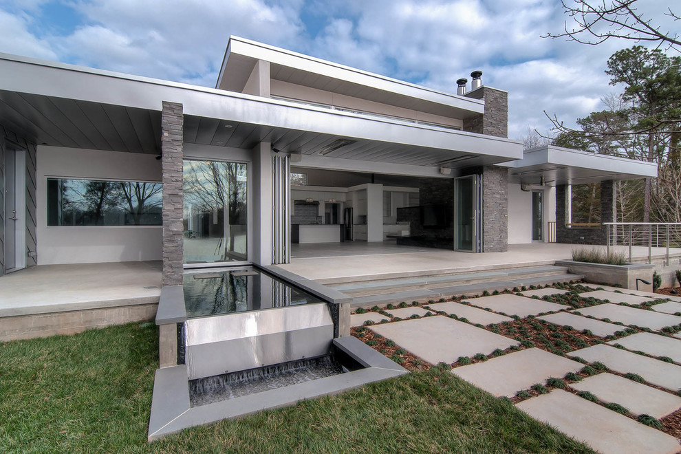 Esempio di un patio o portico minimalista di medie dimensioni e dietro casa con pavimentazioni in cemento e un tetto a sbalzo