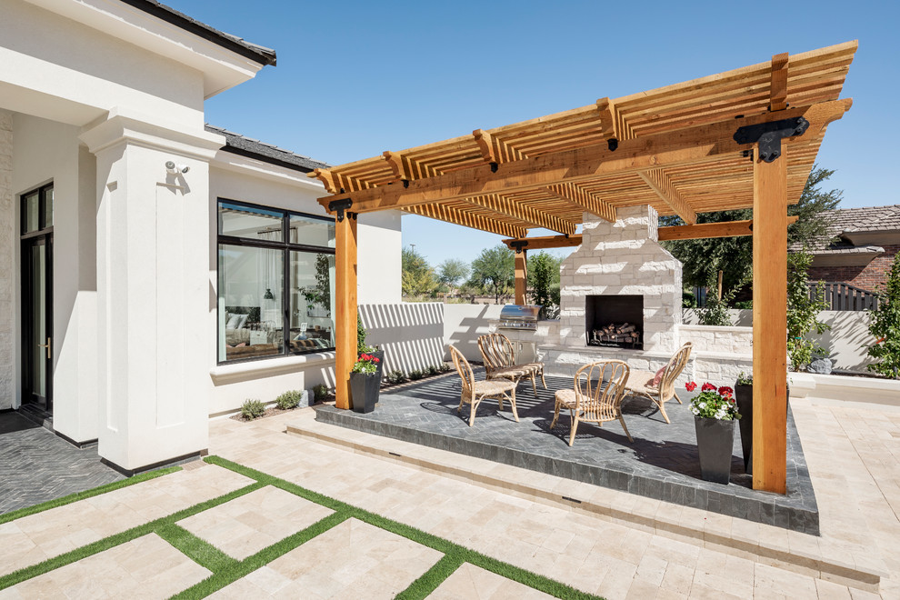 Inspiration for an expansive traditional back patio in Phoenix with natural stone paving, a pergola and a bbq area.