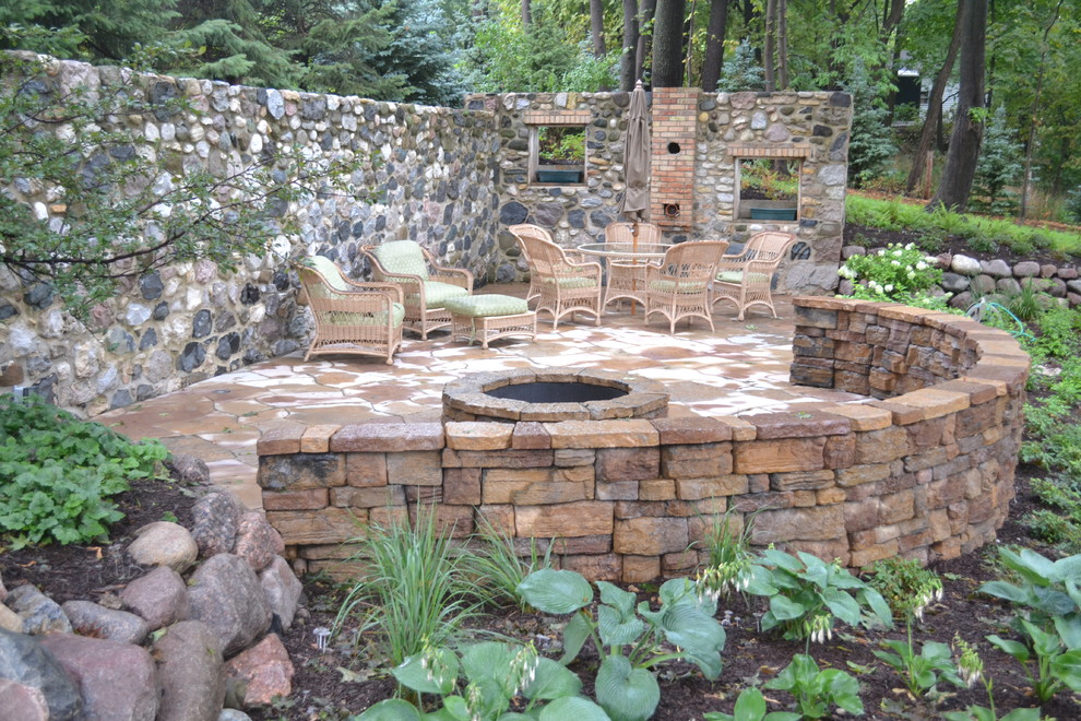 Inspiration for a large rustic front patio in Milwaukee with a fire feature, concrete slabs and no cover.