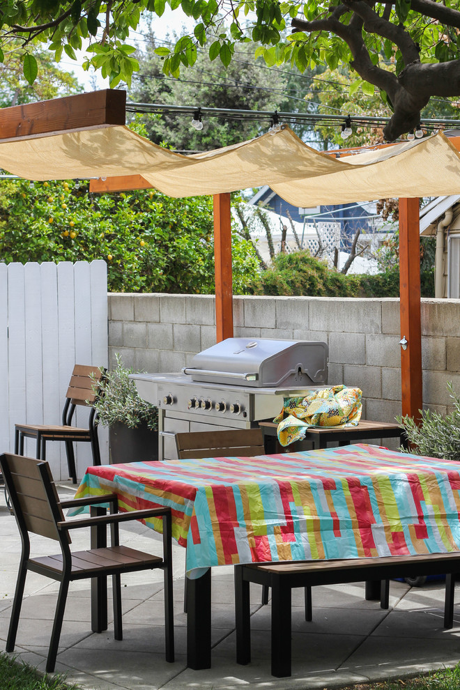 Idée de décoration pour une petite terrasse latérale minimaliste avec une cuisine d'été, une dalle de béton et un auvent.