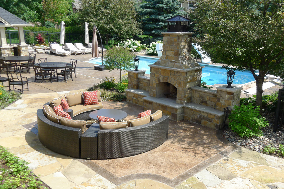 This is an example of a traditional back patio in Minneapolis with a fire feature and stamped concrete.