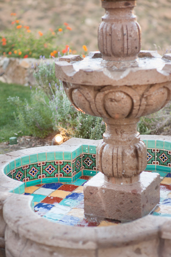 Design ideas for a medium sized mediterranean back patio in San Diego with a water feature and natural stone paving.