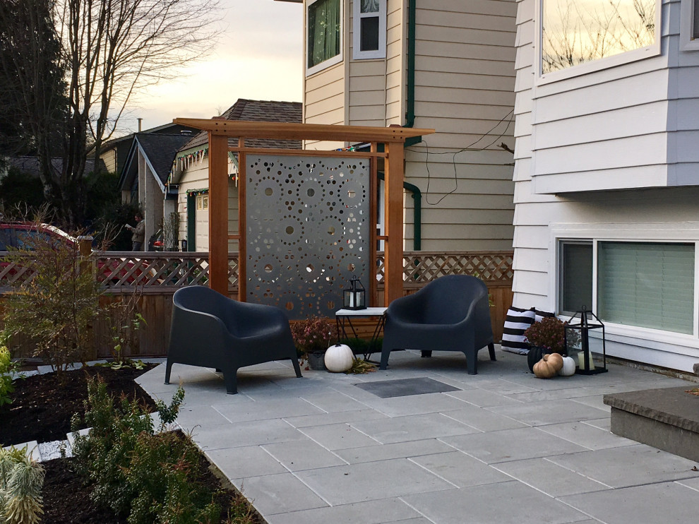 Immagine di un piccolo patio o portico moderno davanti casa con pavimentazioni in cemento