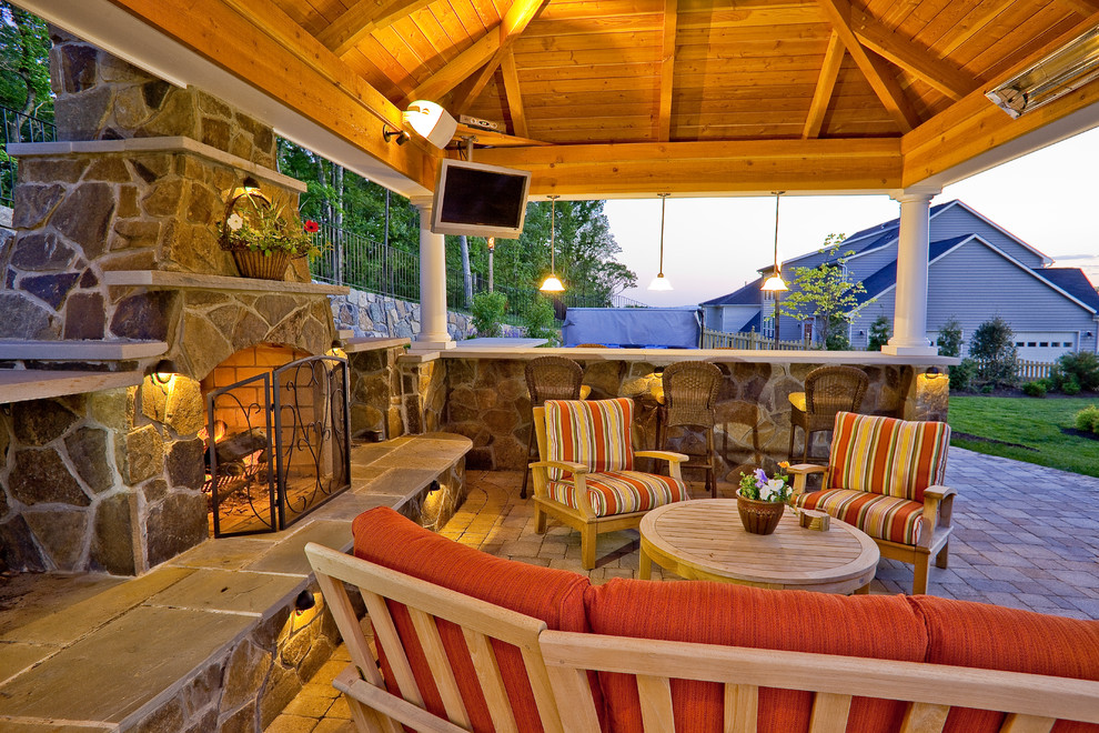 Diseño de patio tradicional grande en patio trasero con brasero, adoquines de hormigón y cenador