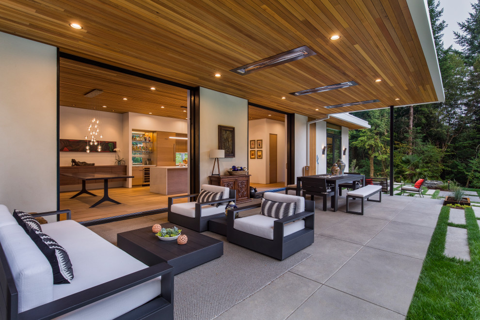 Стильный дизайн: большой двор на заднем дворе в современном стиле с покрытием из бетонных плит и навесом - последний тренд