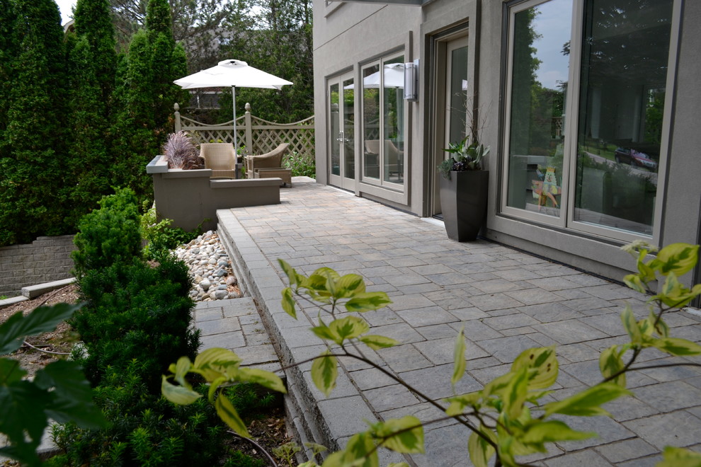 Medium sized rustic front patio in Toronto with concrete paving.