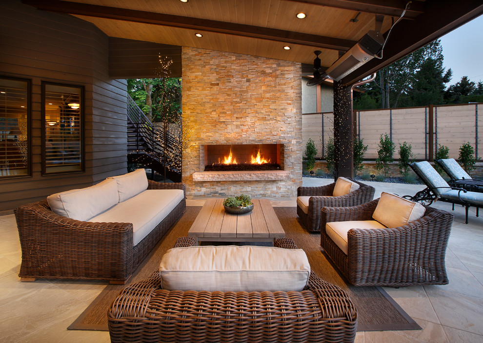 Large contemporary back patio in Salt Lake City with a fire feature, stamped concrete and a roof extension.