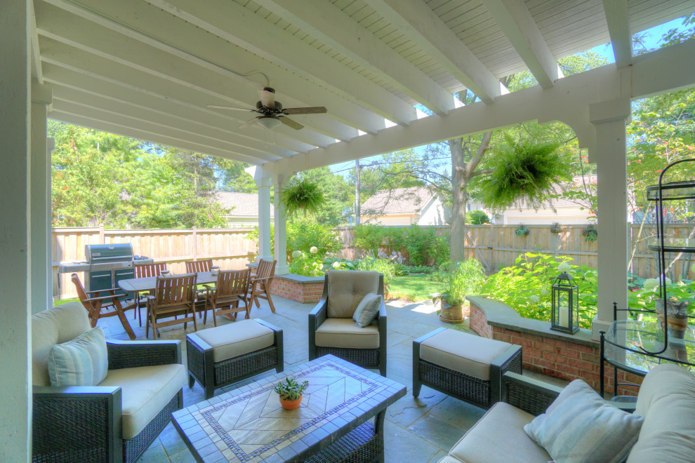 Photo of a small traditional back patio in Chicago with an outdoor kitchen, natural stone paving and a pergola.