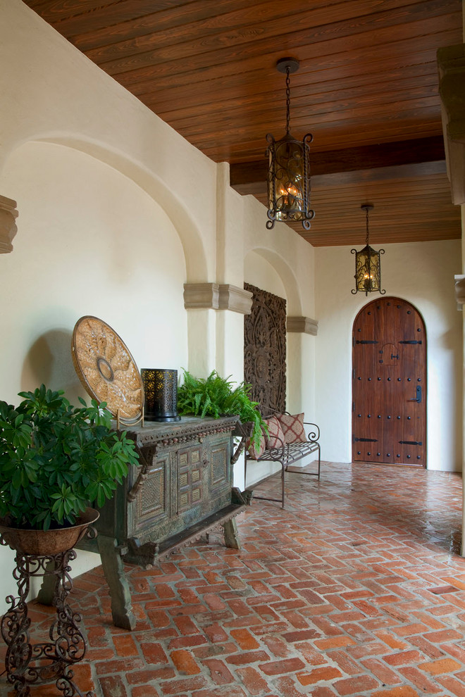 На фото: двор среднего размера на внутреннем дворе в средиземноморском стиле с мощением клинкерной брусчаткой и навесом