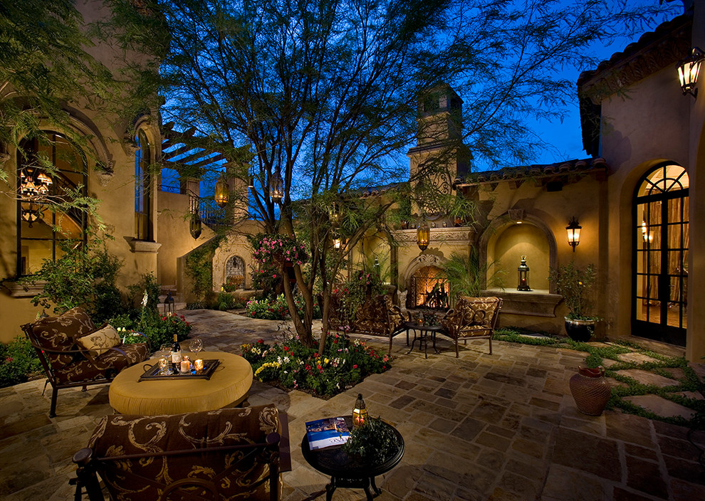 Cette image montre une très grande terrasse traditionnelle avec un foyer extérieur, une cour et des pavés en pierre naturelle.