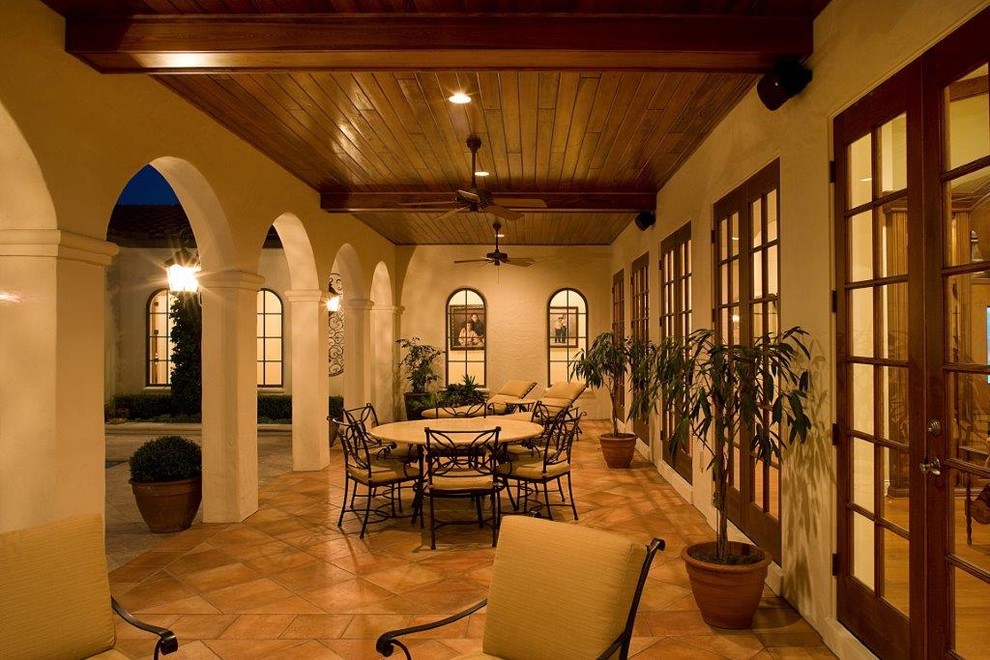 This is an example of a large mediterranean back patio in Orlando with concrete slabs and a pergola.
