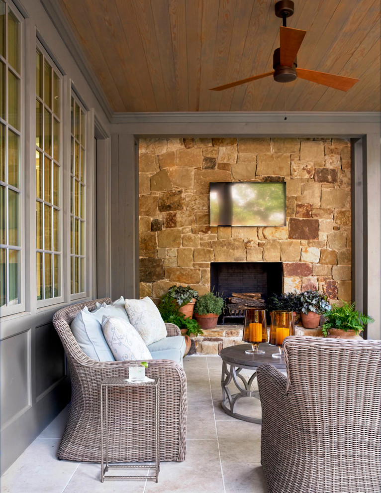 Inspiration for a large traditional back patio in Dallas with a roof extension, natural stone paving and a fireplace.
