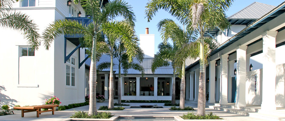 Foto på en stor tropisk uteplats på baksidan av huset, med marksten i betong och takförlängning