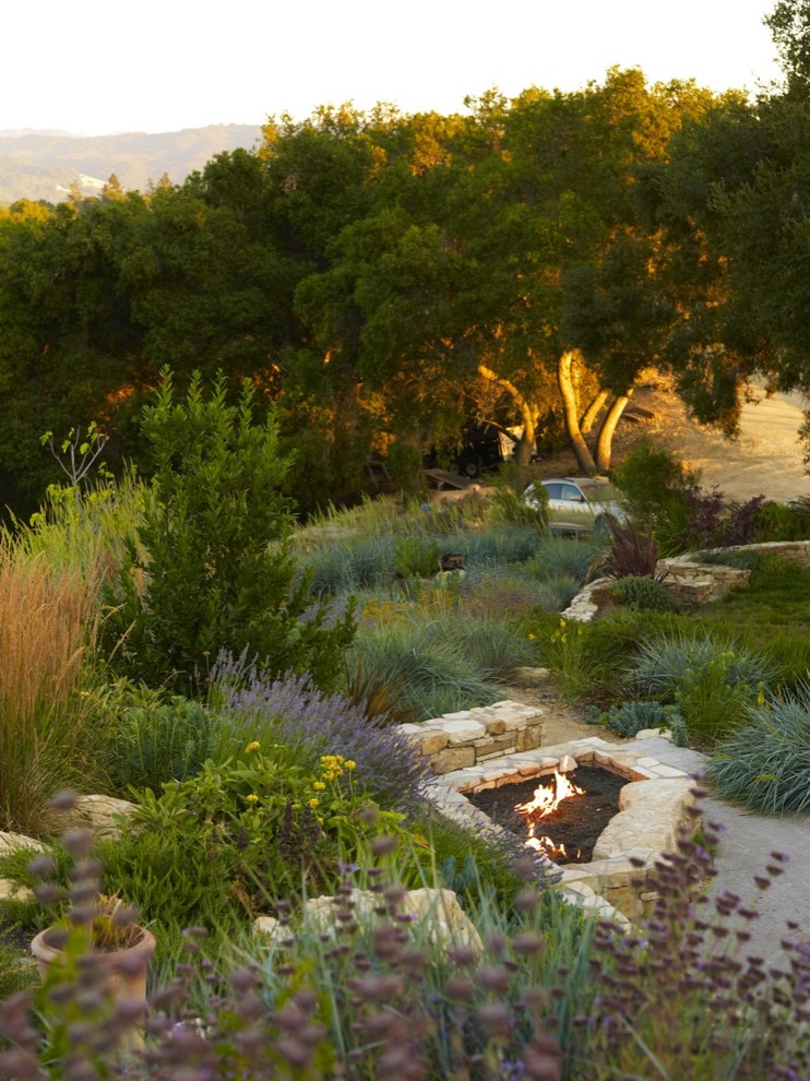 Идея дизайна: большой участок и сад на заднем дворе в современном стиле с местом для костра, покрытием из каменной брусчатки и полуденной тенью