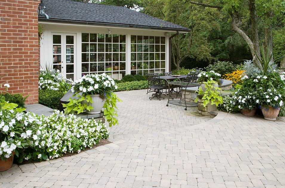 Immagine di un grande patio o portico classico dietro casa con pavimentazioni in cemento e nessuna copertura